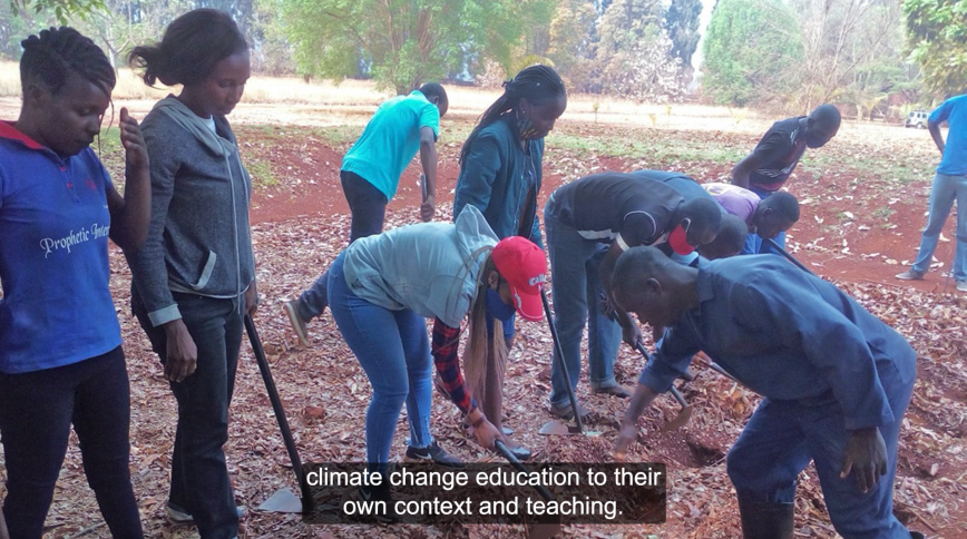 A group of Black teenagers in Africa break up the earth with garden tools.