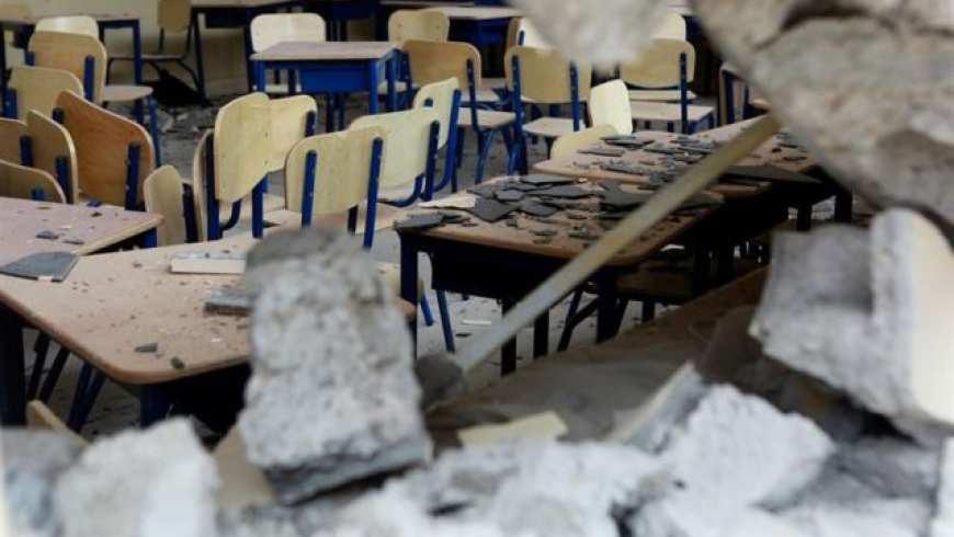 A classroom with rubble on the desks