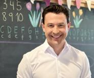 Luis E. García de Brigard stands in front of a chalkboard