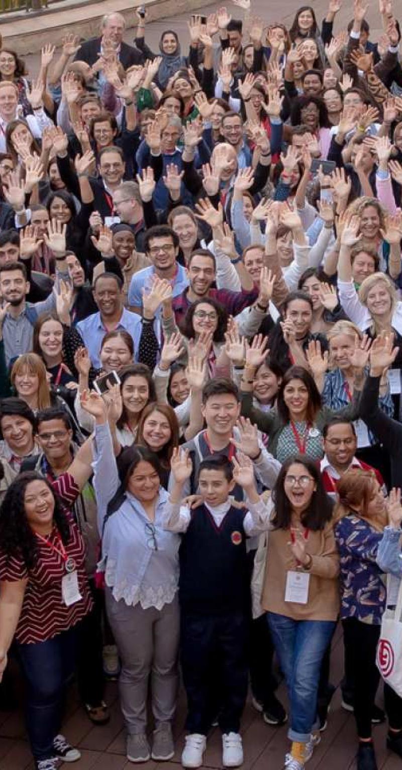 Large group of people waving at the camera