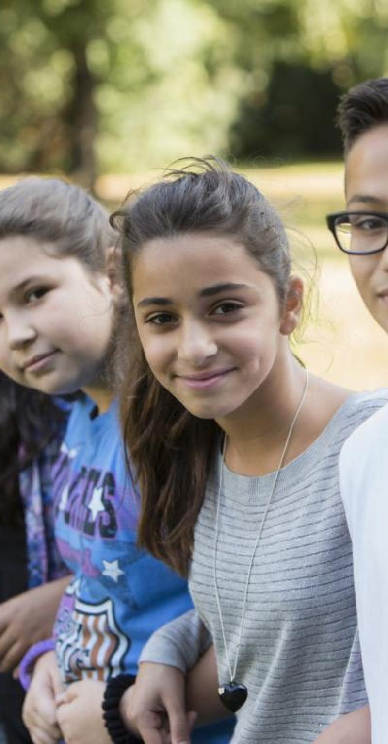 A row of young teens of diverse ethnicities and genders faces the camera