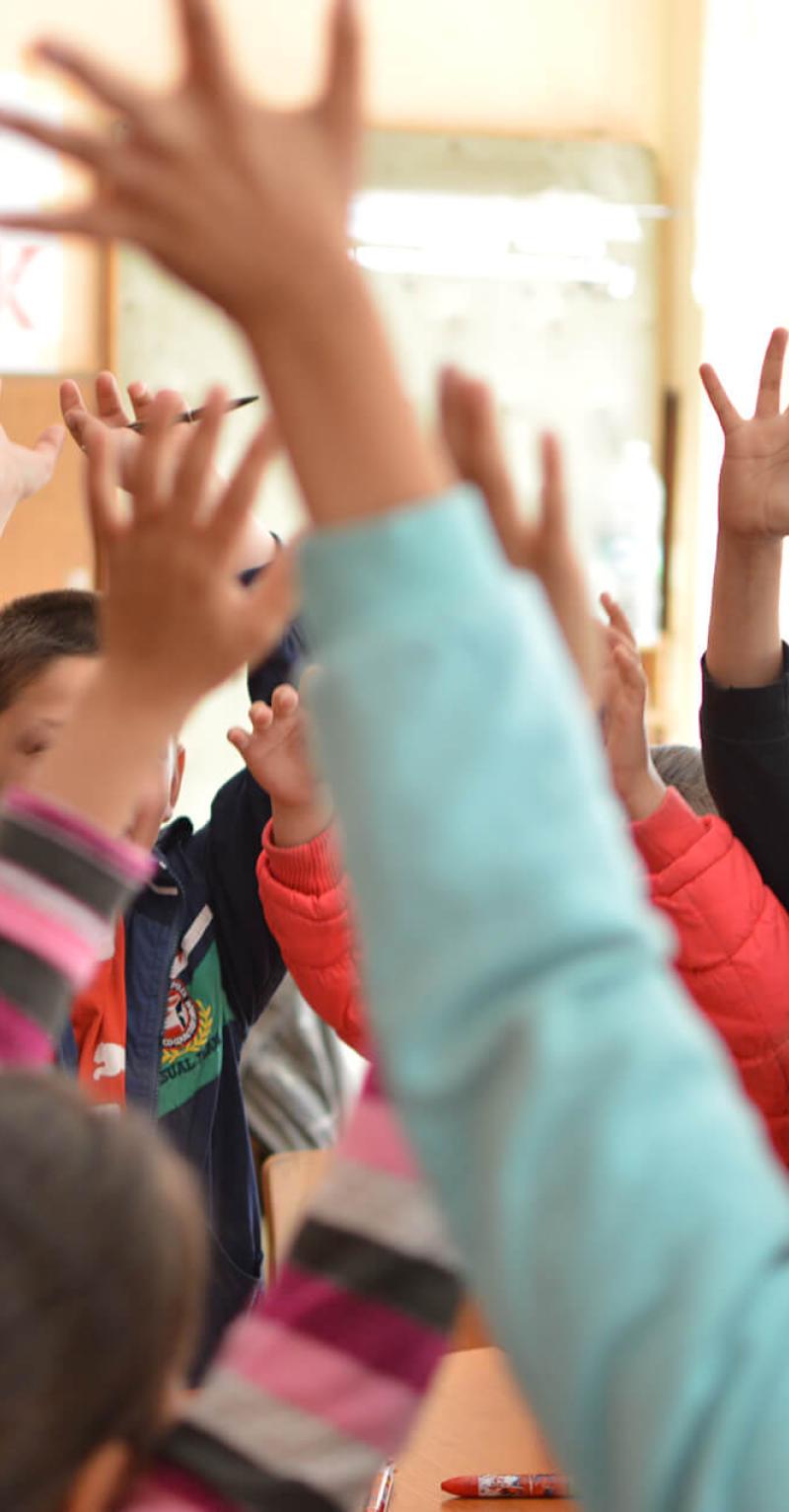 A Teach for All Bulgaria teacher engaging with students in a bright classroom for the FIERST project.