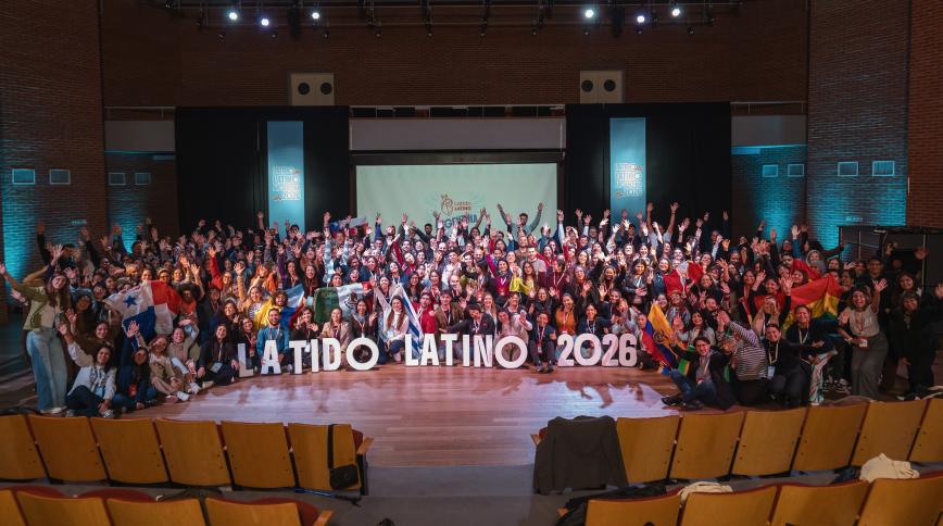 A large crowd of attendees poses on stage behind big 3D letters spelling "LATIDO LATINO 2026" during a conference in Argentina.