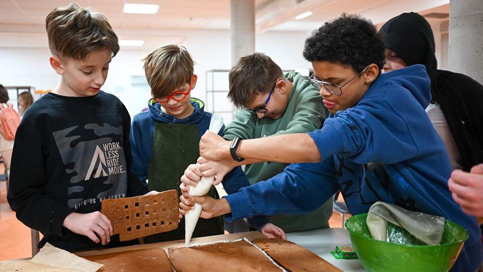 Students assemble a gingerbread model of their school