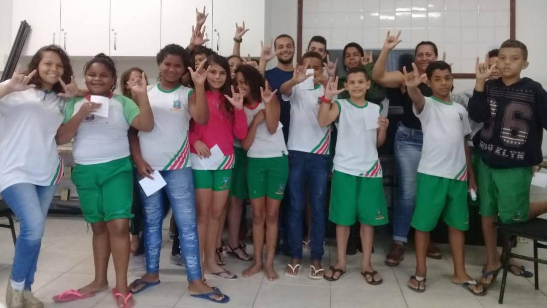 A group of students pose demonstrating the Libras sign for "I love you"