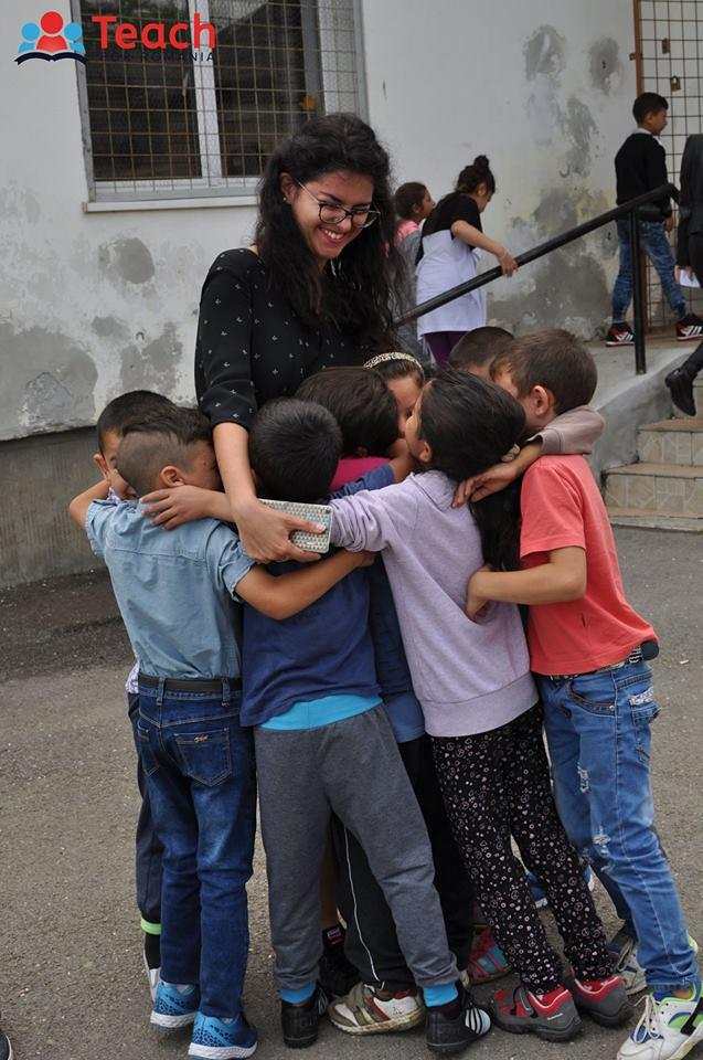 Teacher and a group of children in a group hug